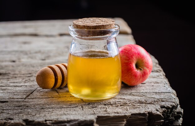 Barattolo e mele del miele sul bello vassoio sul fondo di legno della tavola. festa ebraica rosh hashanah