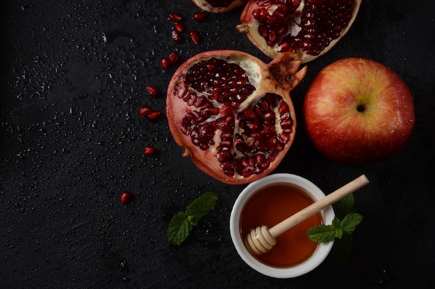 Honey jar, pomegranate, fresh apple. Rosh Hashanah (Jewish New Year holiday) concept.