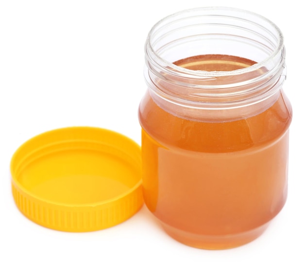 Honey in a jar over white background