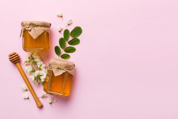 Honey jar with acacia flowers and leaves fresh honey top view flat lay