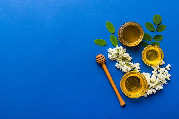 Honey jar with acacia flowers and leaves fresh honey top view flat lay