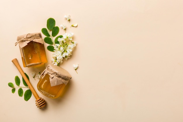 Honey jar with acacia flowers and leaves fresh honey top view flat lay