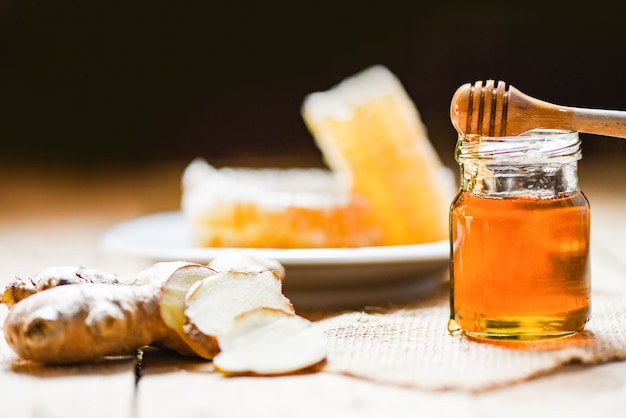 Honey in jar with honey dipper ginger and on wood and honeycomb 