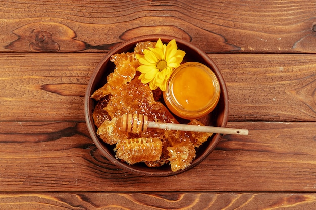 Honey in jar with honey dipper on vintage wooden 