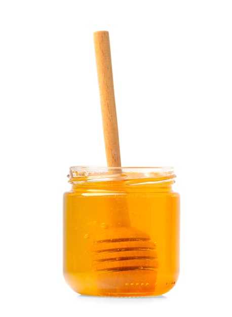 Honey in a jar with a wooden dipper on a white isolated background