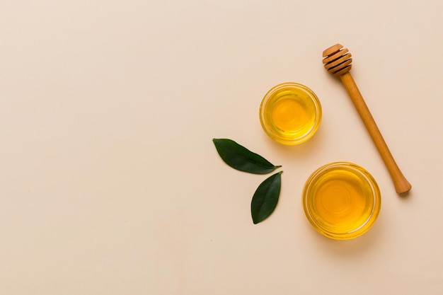 Honey jar with wooden honey dipper on white background top view with copy space Delicious honey bottle