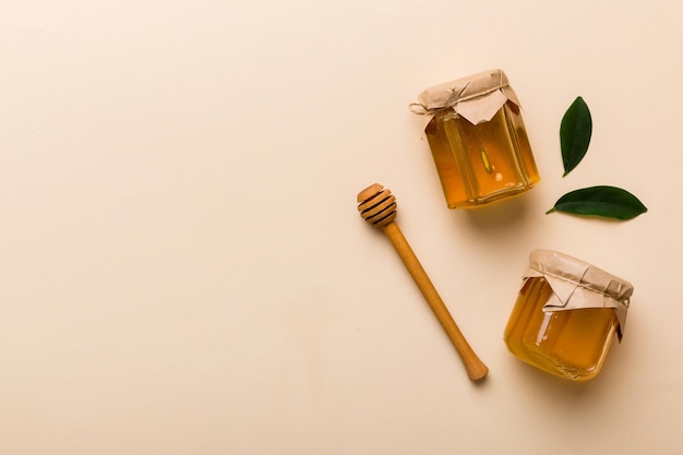 Honey jar with wooden honey dipper on white background top view with copy space Delicious honey bottle