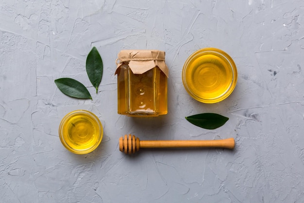 Honey jar with wooden honey dipper on white background top view with copy space Delicious honey bottle