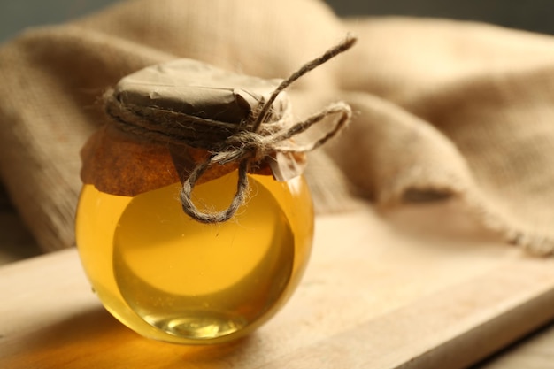 Honey jar on wooden background