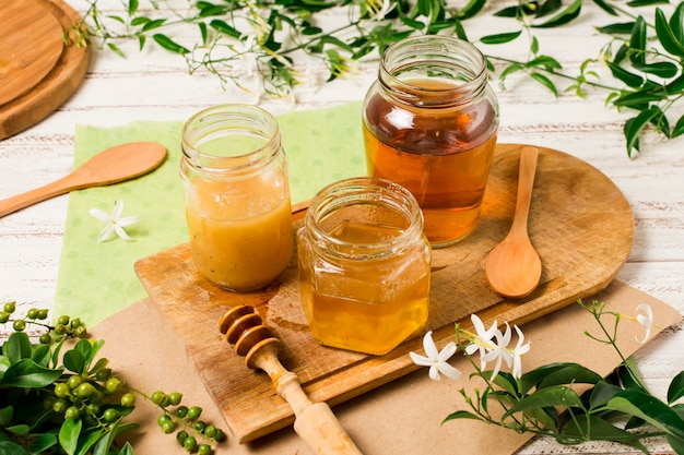 Photo honey jars on table with leaves