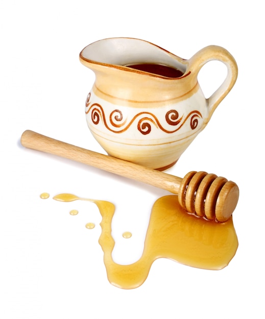 Honey in a jug and wooden stick