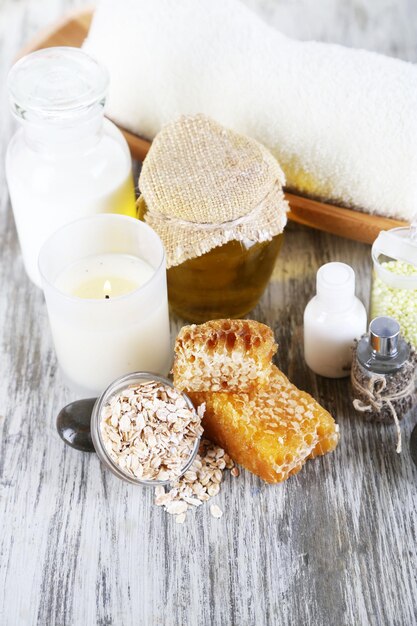 Photo honey and milk spa with oils and honey on wooden table closeup