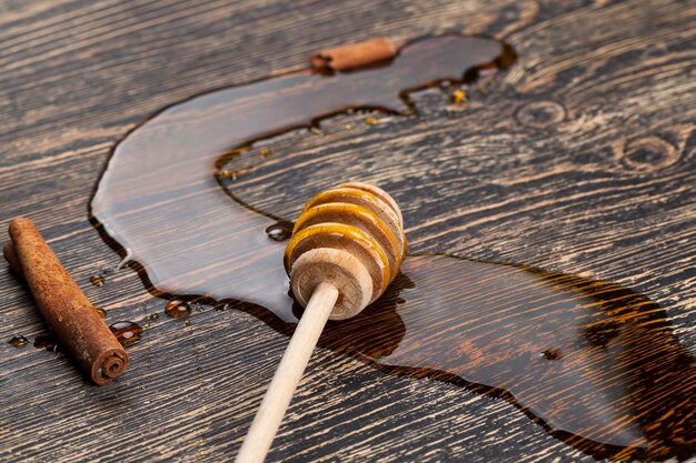 Honey spreading on the table a closeup of honey and honey spoons on a wooden table