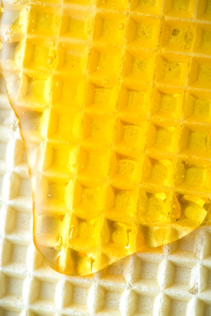 ワッフルのクローズアップの蜂蜜の甘い釉薬甘い食べ物の背景を表示