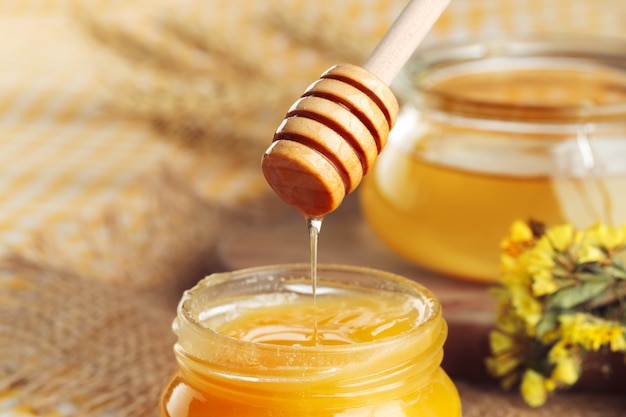 Honey. Sweet honey in glass jar on wooden.