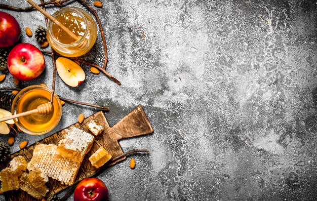 Honey table. Honey with apples and nuts. On rustic table.