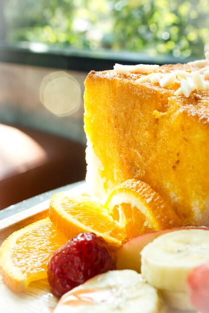 Медовый тост со свежими фруктами на деревянной тарелке.