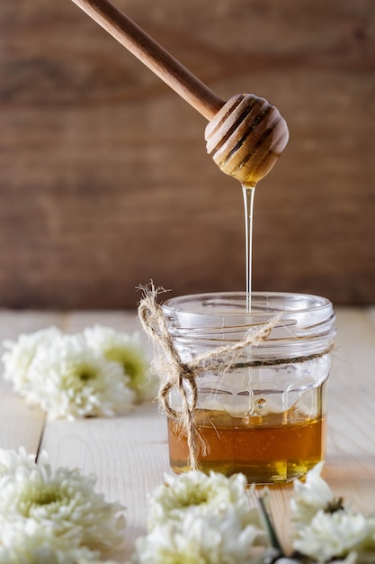 Honey with dipper on wooden table