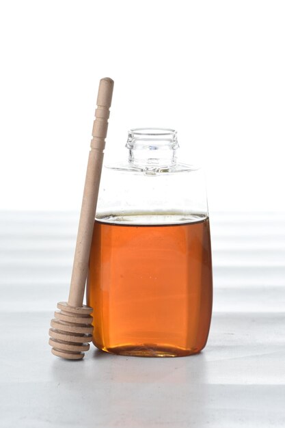 honey with honey dipper isolated white background