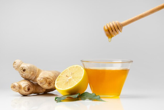 Honey with lemon and ginger on white background