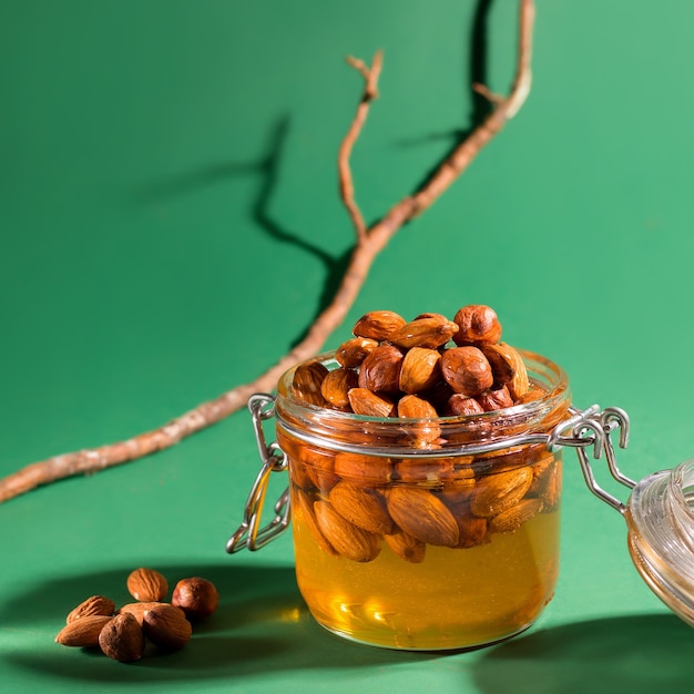 Honey with nuts on a dark green background.