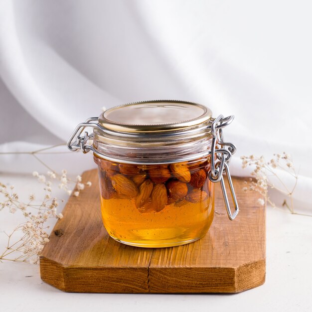 Photo honey with nuts on a wooden board.