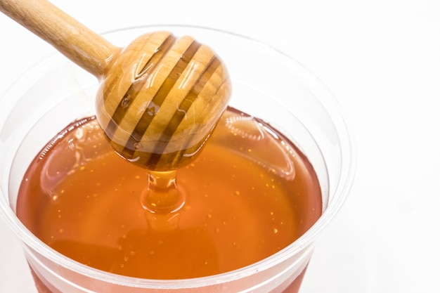 Honey with wood stick on white background.