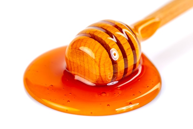 Honey with wooden dipper isolated, food