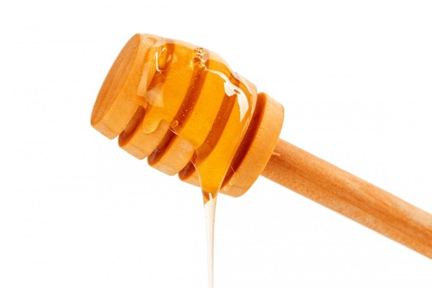 Honey with wooden drizzler isolated on white background