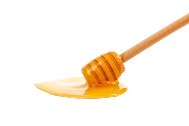 Honey with wooden drizzler isolated on white 