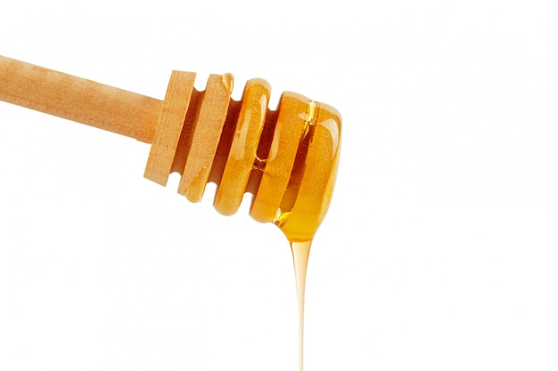 Honey with wooden drizzler isolated on white 