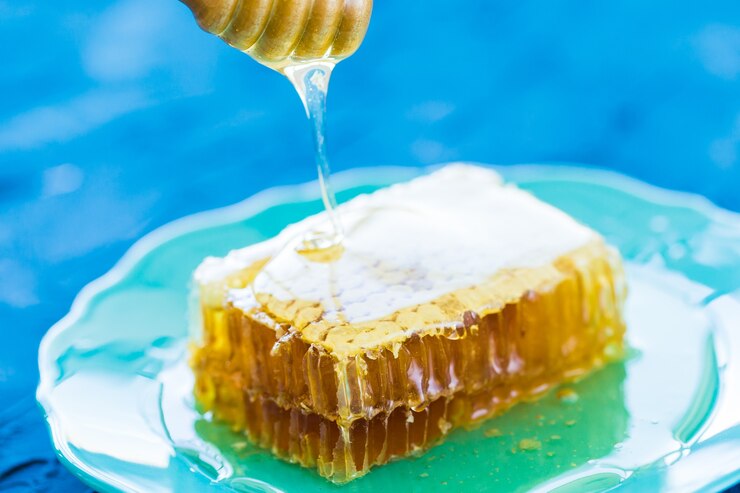 Photo honey with wooden honey dipper and honeycombs, close-up