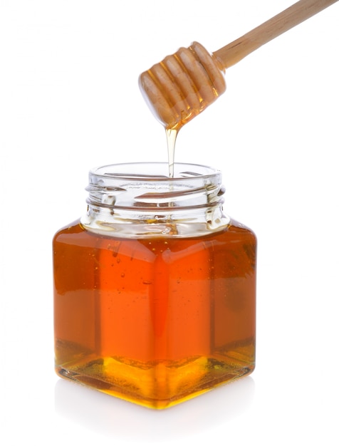 Photo honey with wooden honey dipper on jar