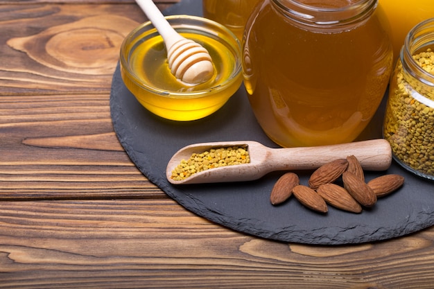 Honey with wooden honey dipper on wooden table