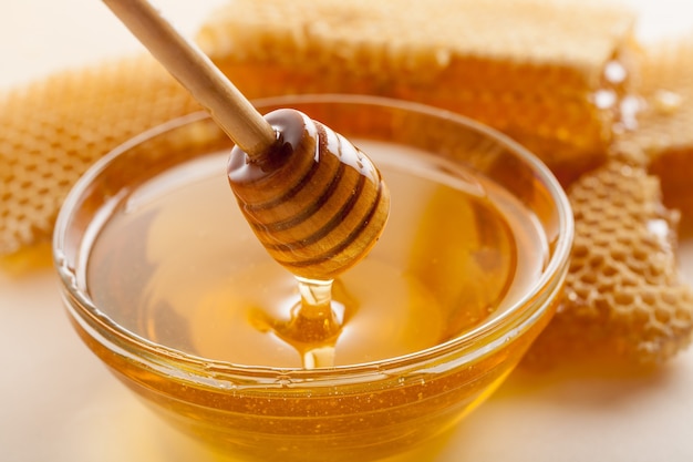 Honey and  wooden spoon  on background