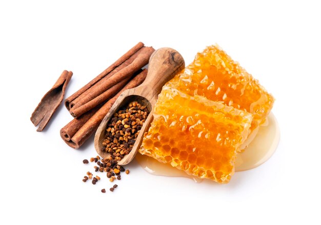 Photo honeycomb with honey and pollen with cinnamon on white backgrounds healthy food ingredient