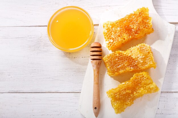 Honeycombs and bowl of honey on wooden table