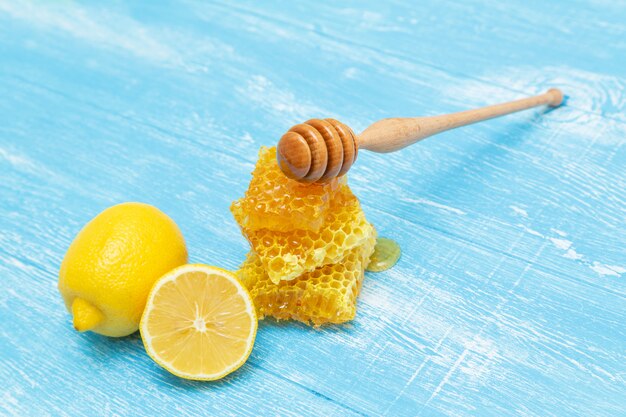 Honeycombs and lemon lie on a blue wooden .
