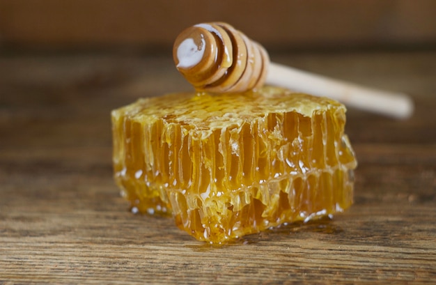 Honeycombs lie on the table, on top is a honey stick. Aesthetics