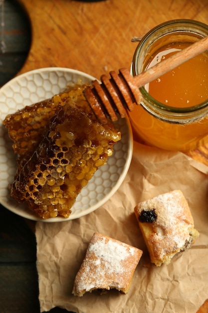 Honeycombs on plate hot buns on wooden background