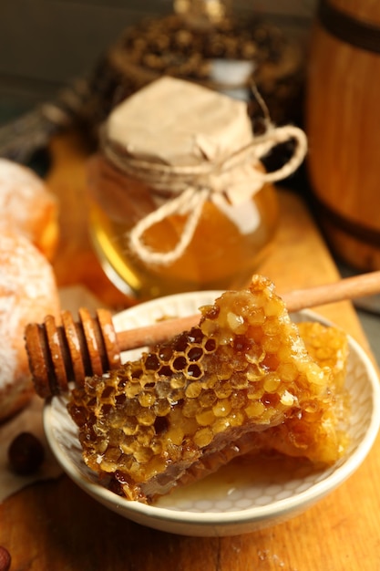 Honeycombs on plate hot buns on wooden background