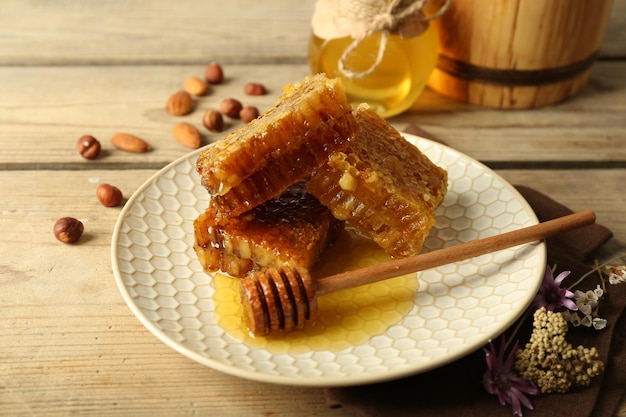 Honeycombs on plate on wooden background