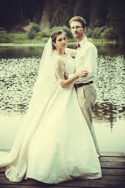 Honeymoon. The bride and groom hugging on the shore of Lake.