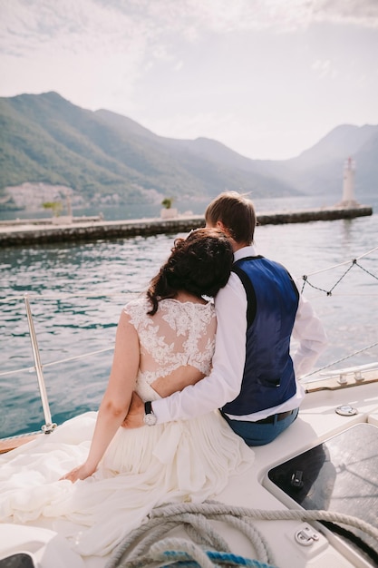 Honeymoon couple travel Europe on yacht Back view Montenegro Perast