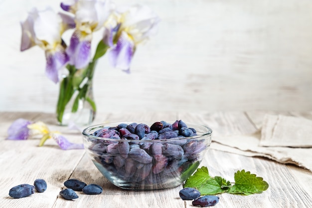 Honeysuckle vase on wooden table with berry