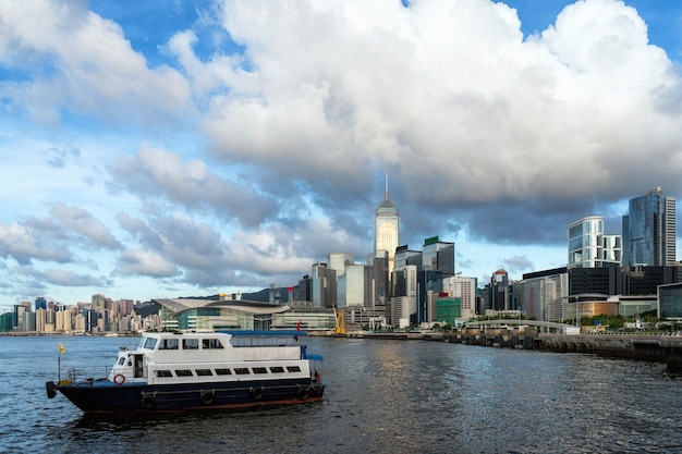 Lato del fiume di paesaggio urbano di hong kong nel pomeriggio con la barca del trasporto e la nuvola liscia