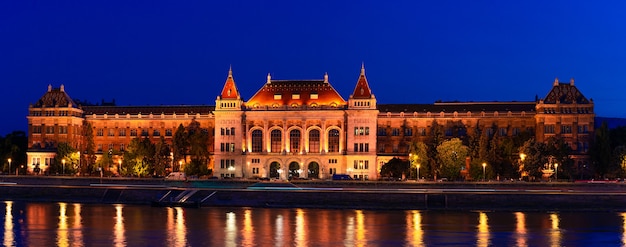 Hongarije, Boedapest bij nacht, universiteitsgebouw aan de oever van de Donau, de weerspiegeling van licht in het water