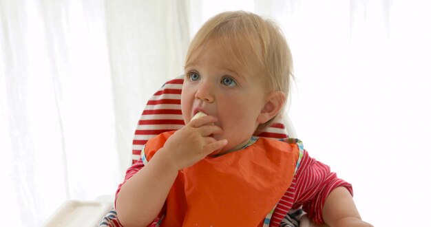 Hongerig babymeisje dat een banaan eet.