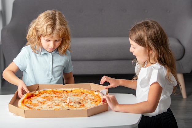 Hongerige kinderen die pizza eten Kinderen bereiden zich voor om verse pizza te eten