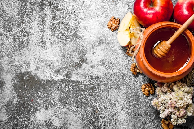 Honing achtergrond. geurige honing in een pot met appels en kruiden op rustieke tafel.